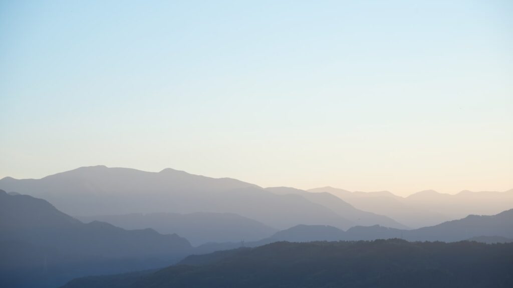 alt="淡い光に包まれた山の風景（記事終盤の余韻をイメージした背景）"