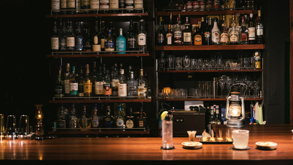 アニメ『勇者の数』1話エンディング用
二人分のカクテルやおつまみが並んだおしゃれなバーのカウンターの様子の写真