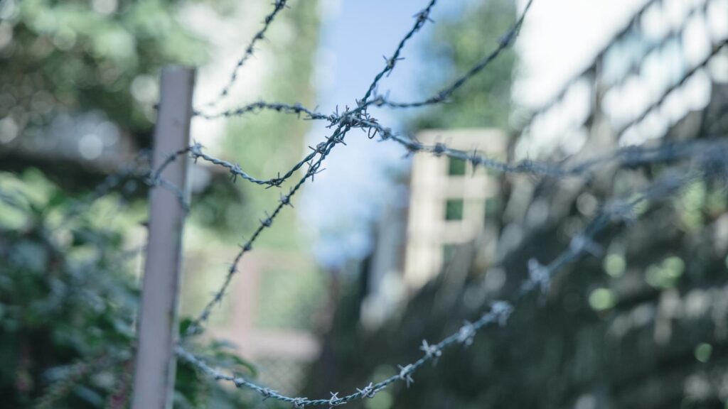 アニメ『勇者のクズ』２話　感想まとめ記事導入用
有刺鉄線の向こうに広がる静寂の風景の写真